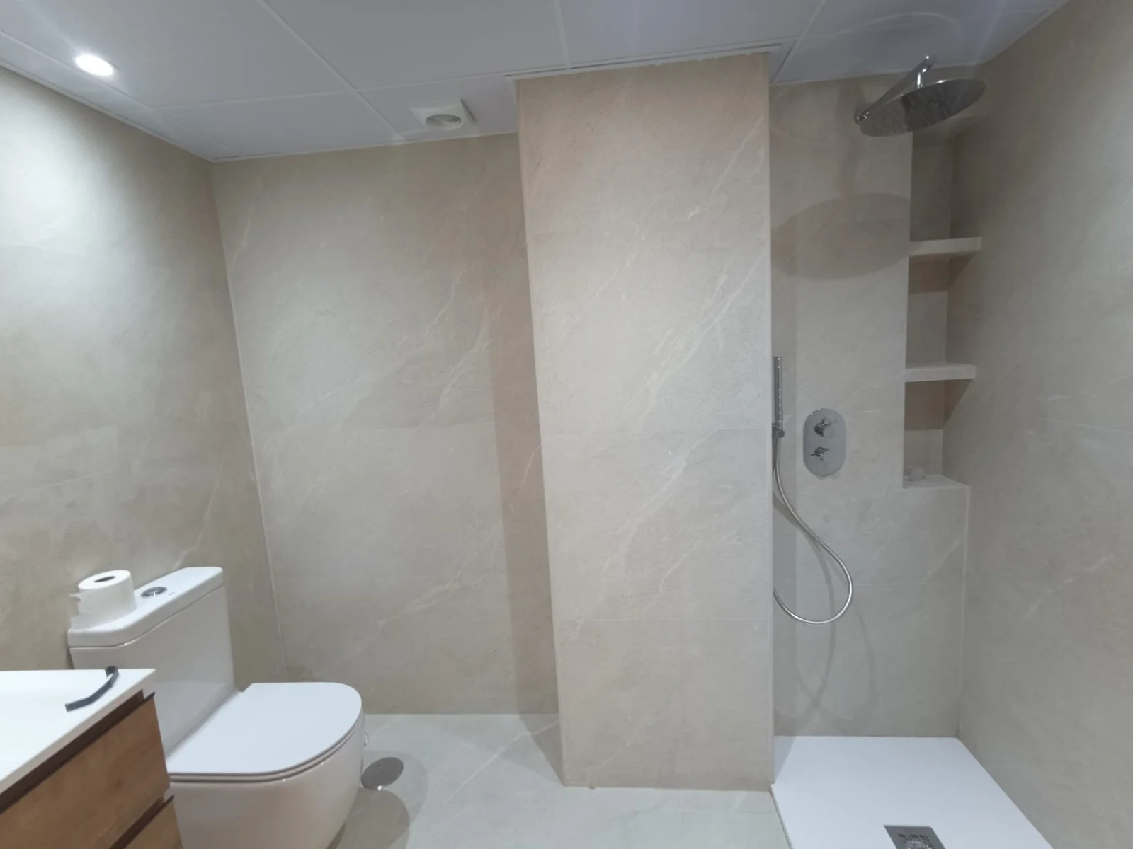 Baño terminado con plato de ducha y hornacinas en la pared alicatada