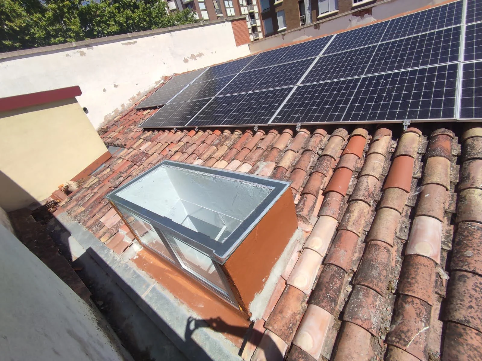 Placas solares y ventana de tejado sobre la cubierta de teja